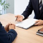 女性弁護士が相談者に書類を示しながら説明している法律相談の様子